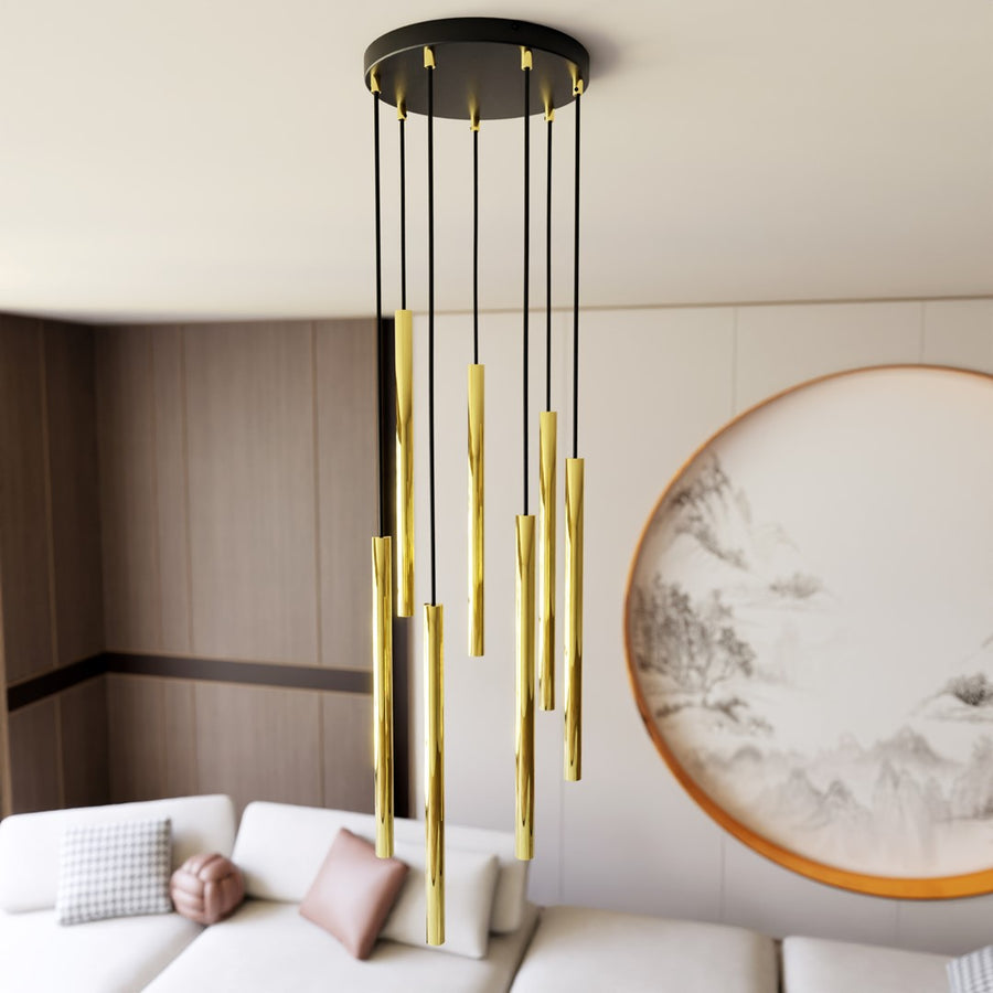 Suspension dorée installée au plafond dans un salon, tubes dorés à hauteurs variables