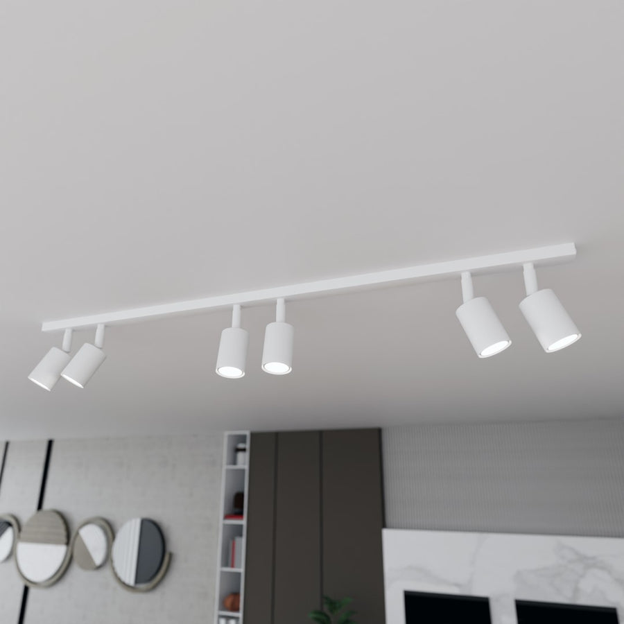 Détail en plongée des six projecteurs blancs montés sur une barre au plafond.