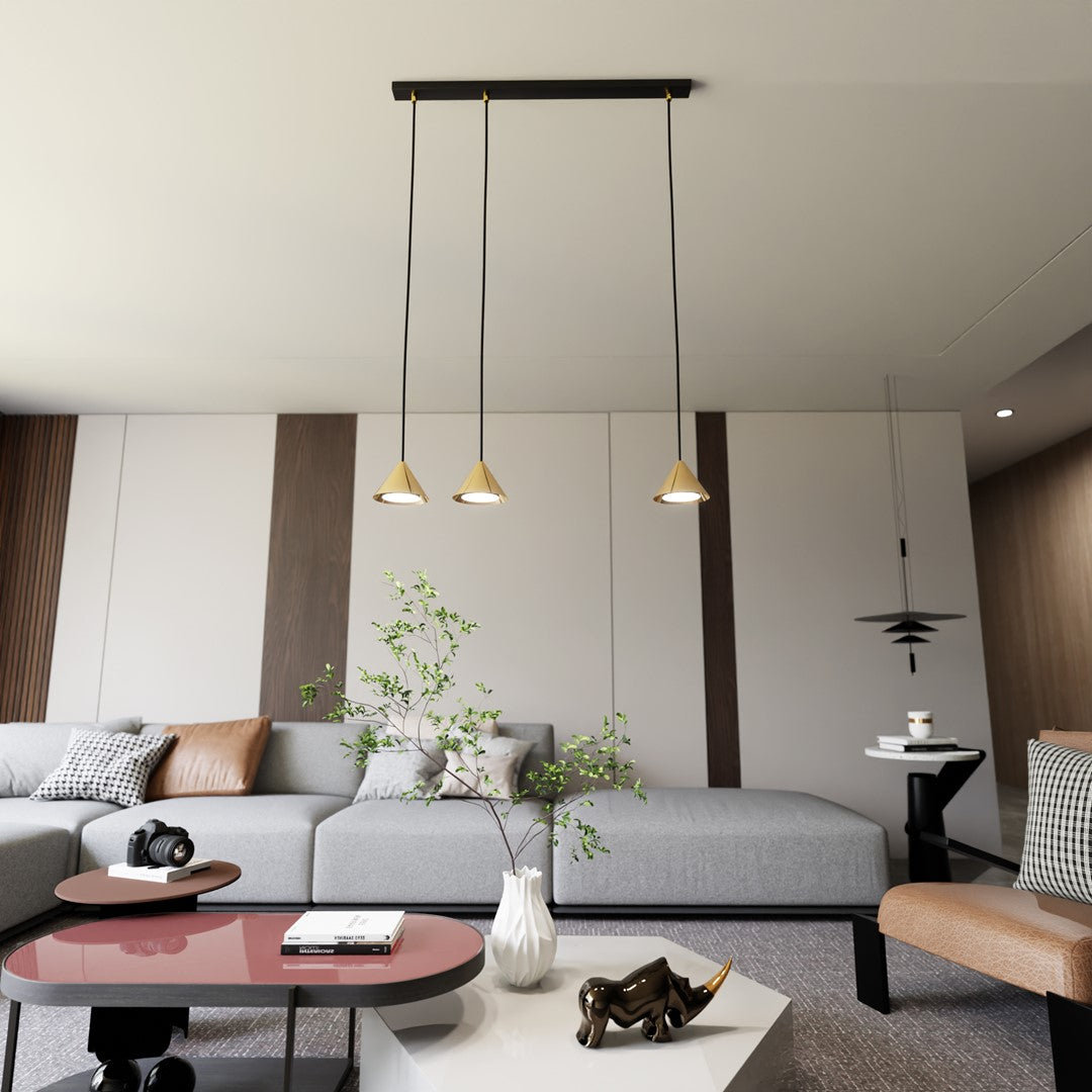 Mise en ambiance dans un salon clair, suspension dorée au-dessus du canapé et table basse.