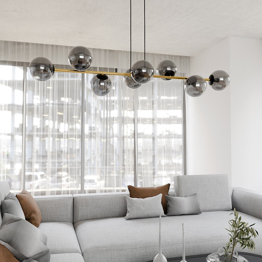 Suspension éteinte dans un séjour moderne, globes fumés reflétant la lumière près des fenêtres.