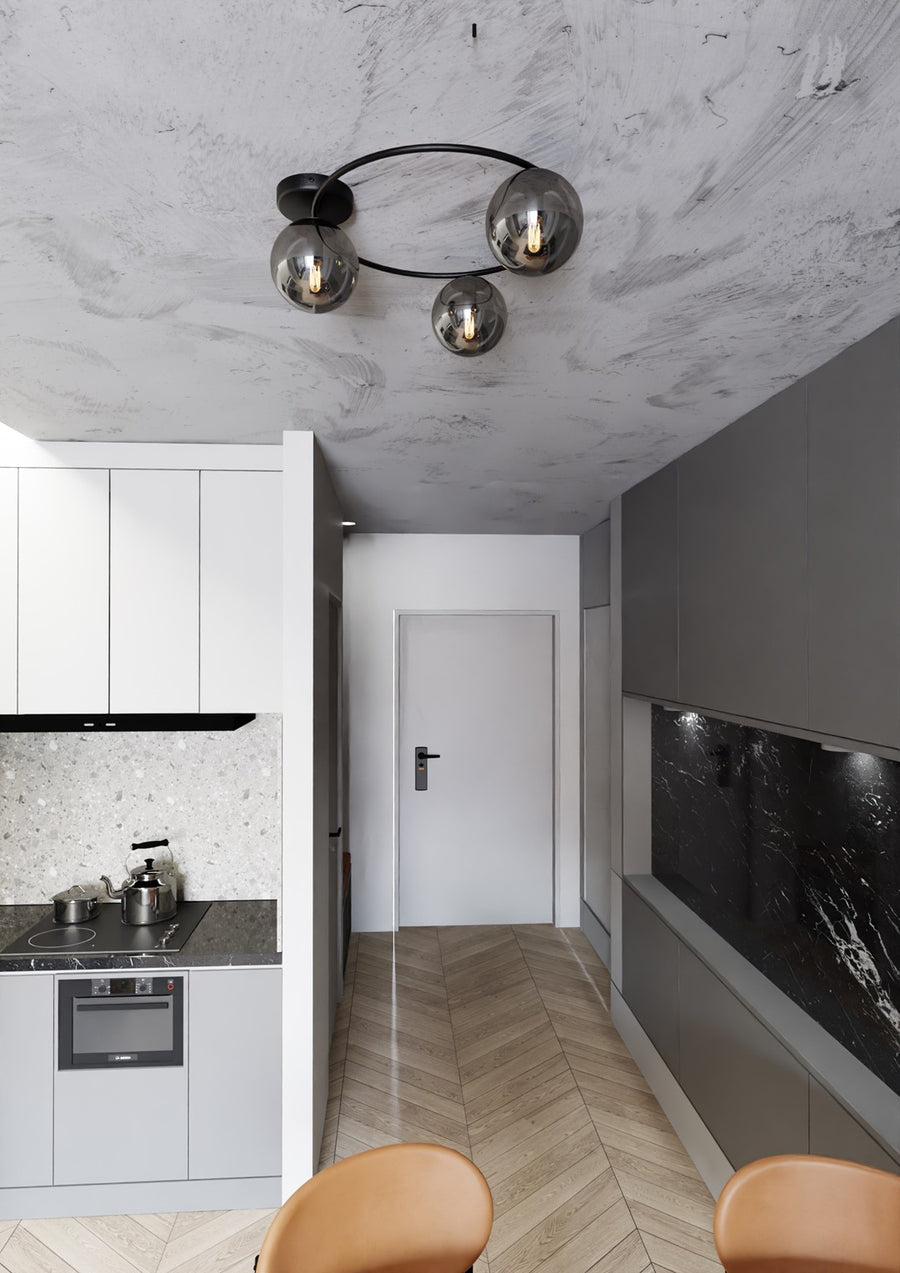 Plafonnier installé dans un couloir de cuisine, plafond marbré et meubles gris.