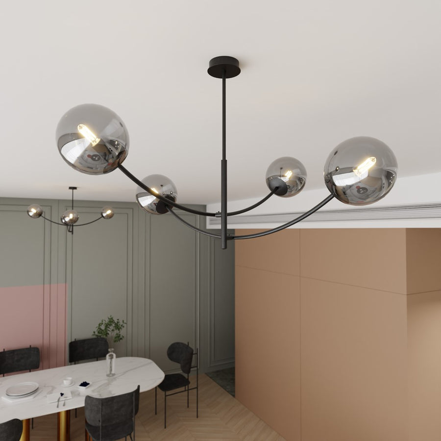 Gros plan du plafonnier à quatre globes au-dessus d'une table de salle à manger.