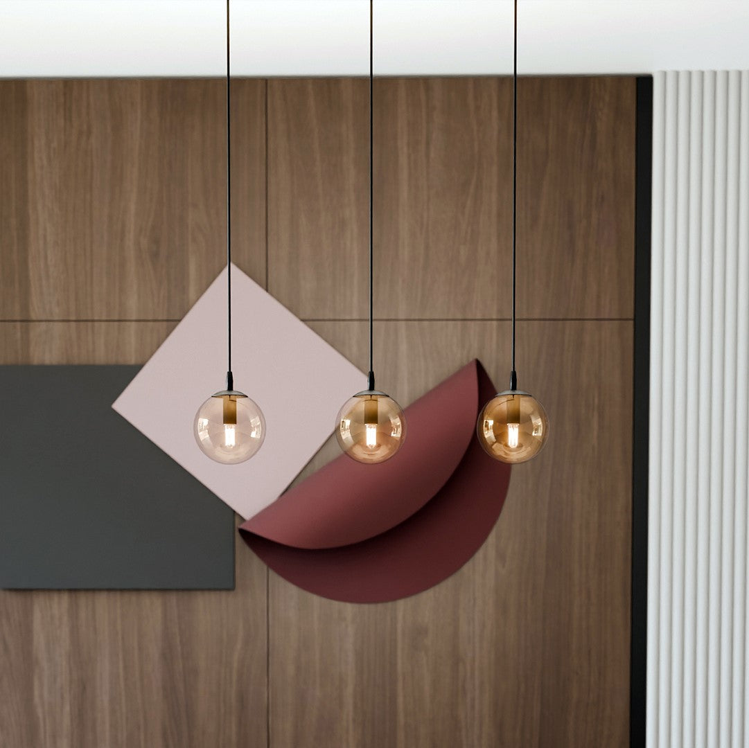 Détail des globes ambrés devant un mur bois et des formes géométriques colorées.