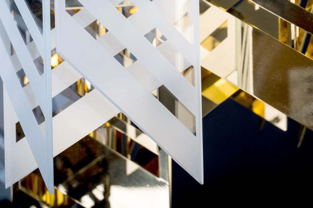 Détail de la finition, panneau blanc ajouré devant un miroir doré réfléchissant