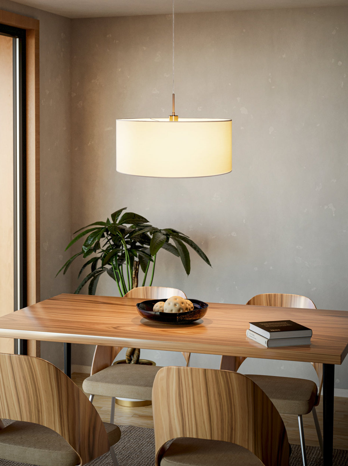 Mise en ambiance au-dessus d'une table à manger en bois clair, suspension allumée