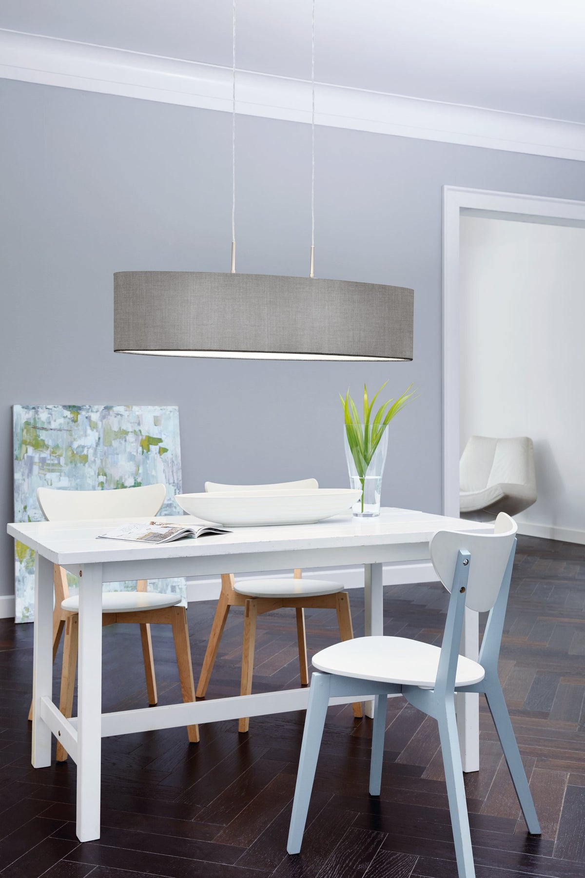 Mise en ambiance au-dessus d'une table de salle à manger blanche et chaises bleues