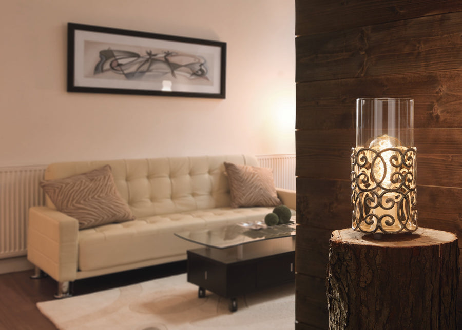 Lampe allumée dans un salon, sur souche de bois devant un canapé beige