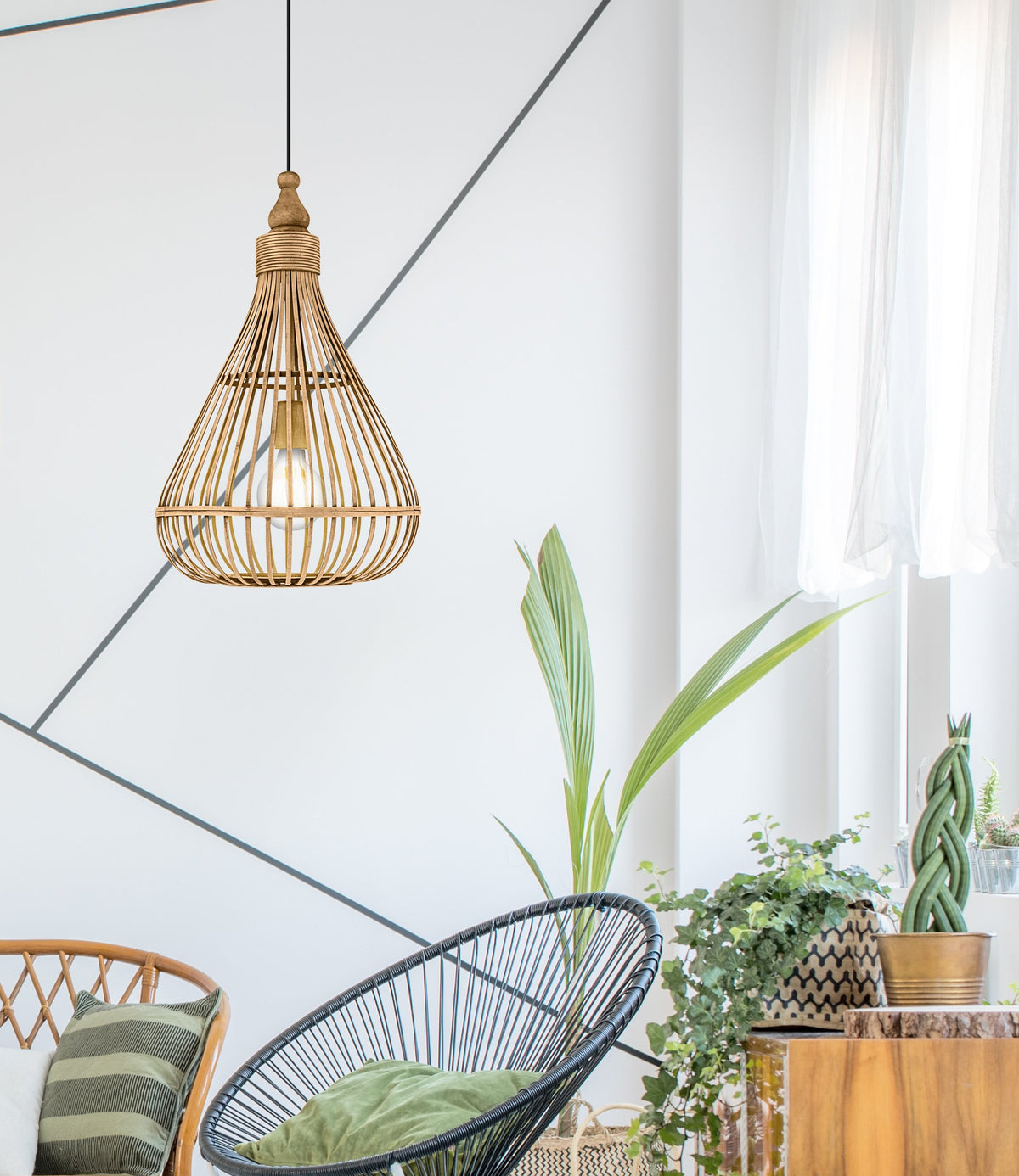 Lampe suspendue en rotin dans un intérieur lumineux avec plantes et fauteuil.