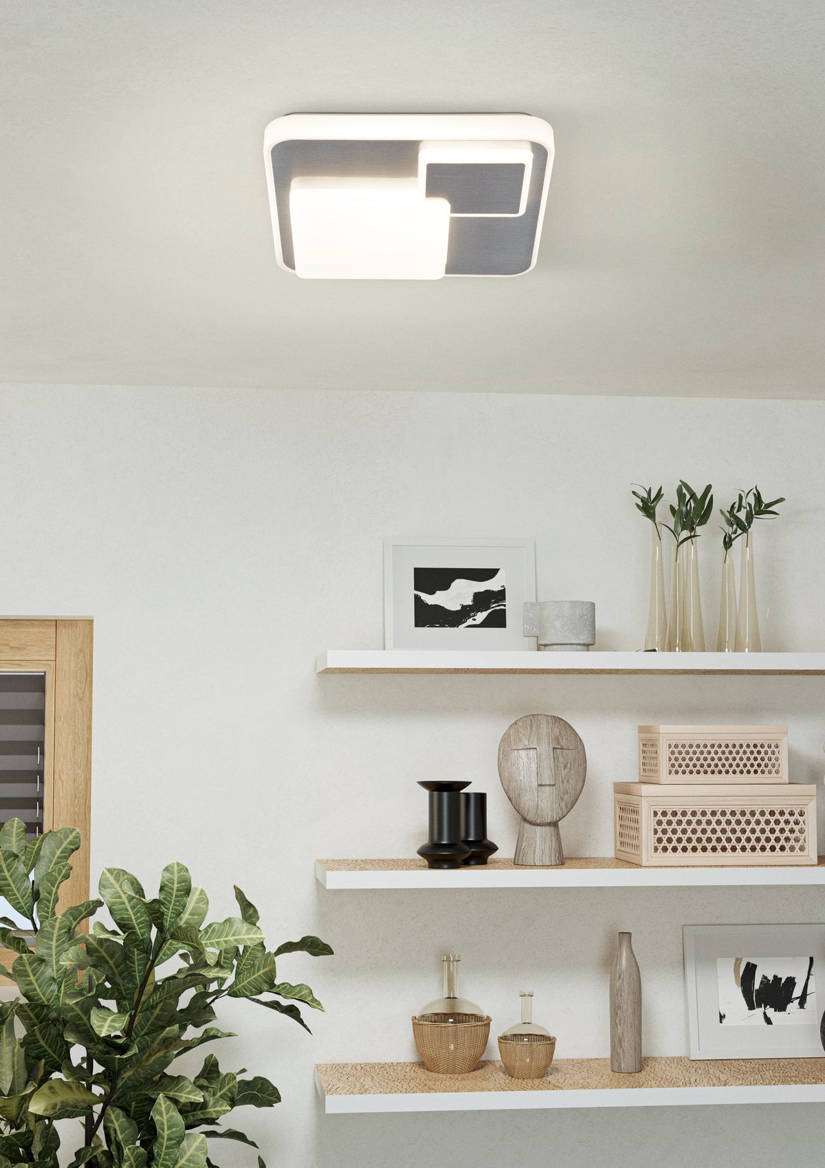 Plafonnier moderne en situation, au-dessus d'étagères décorées et d'une plante verte.