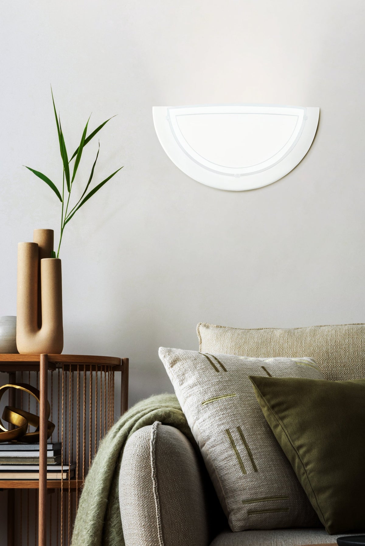 Mise en ambiance de l'applique demi-lune au-dessus d'un canapé beige