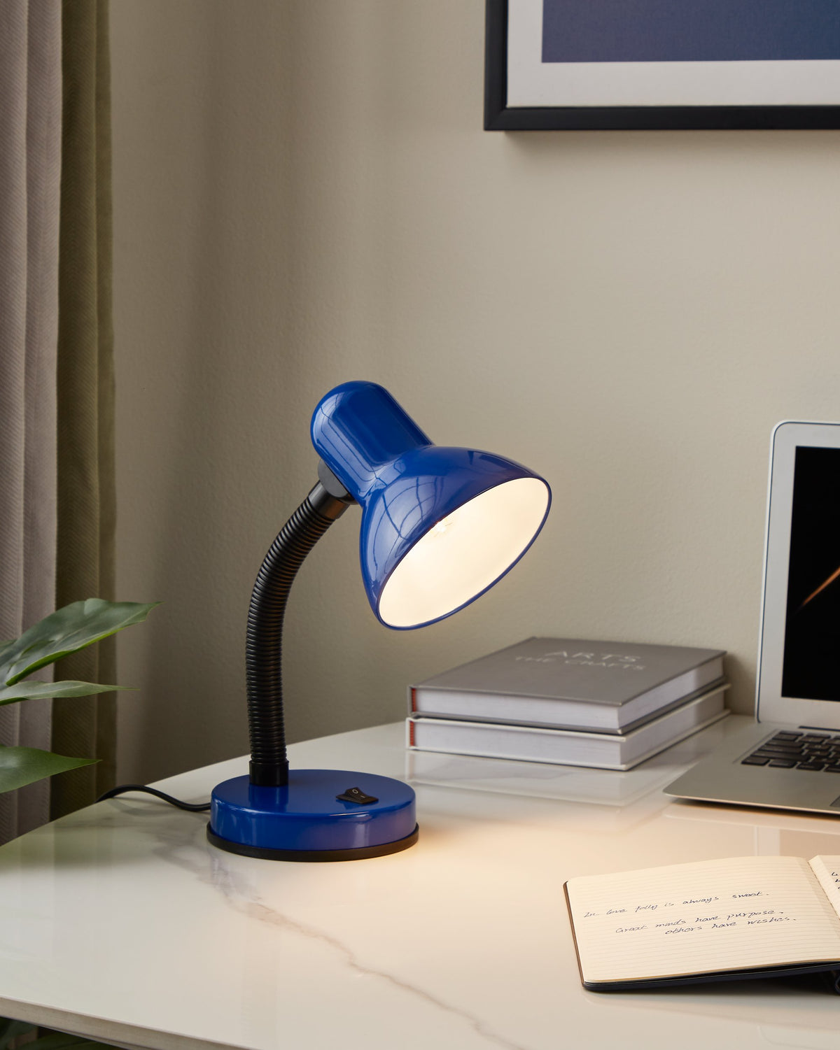 Mise en ambiance bureau avec lampe allumée éclairant un carnet manuscrit.