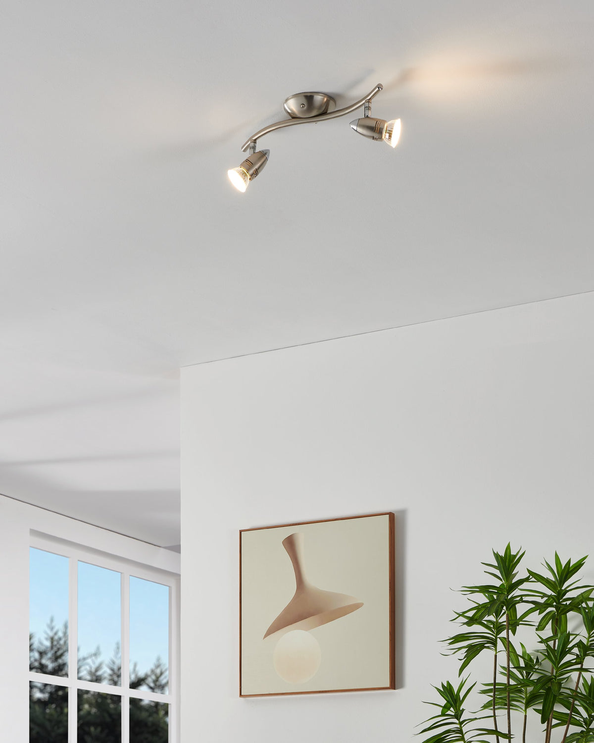 Mise en ambiance d'un plafonnier allumé fixé au plafond blanc d'un salon contemporain