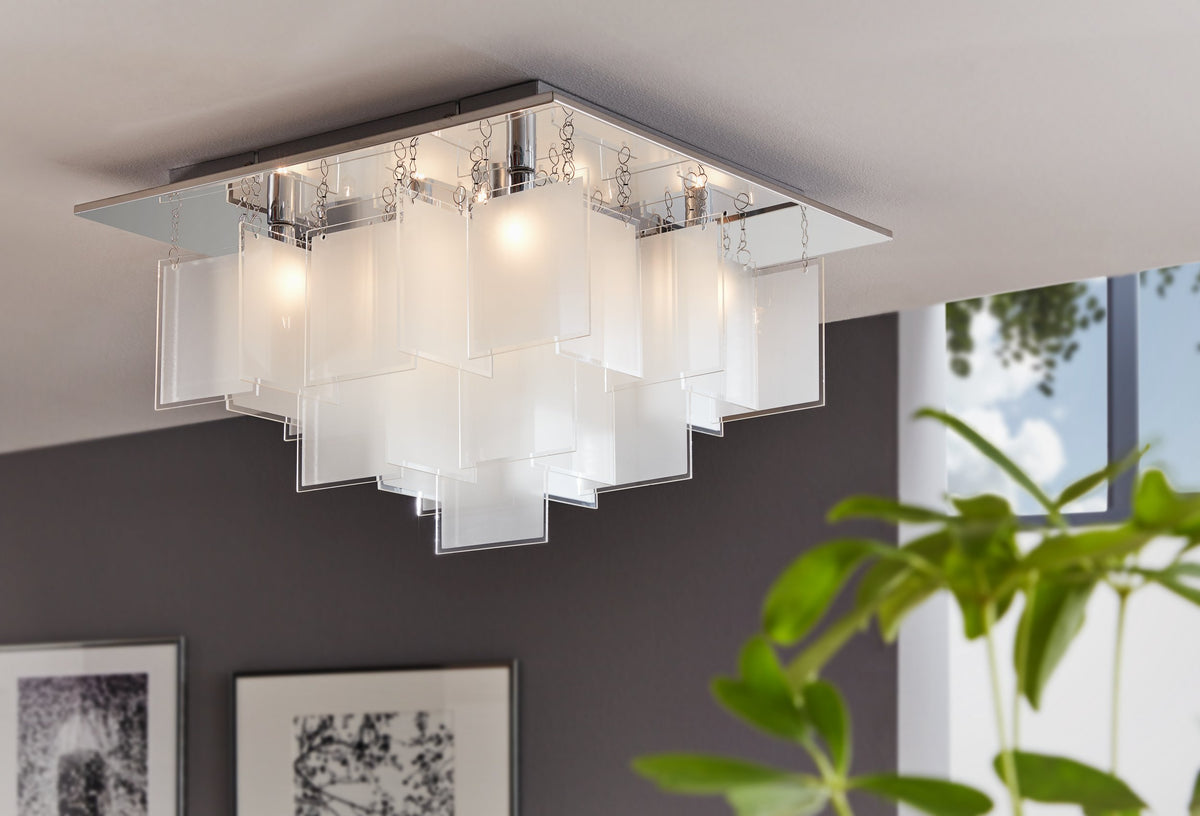 Luminaire allumé fixé au plafond dans un salon, panneaux de verre étagés en cascade