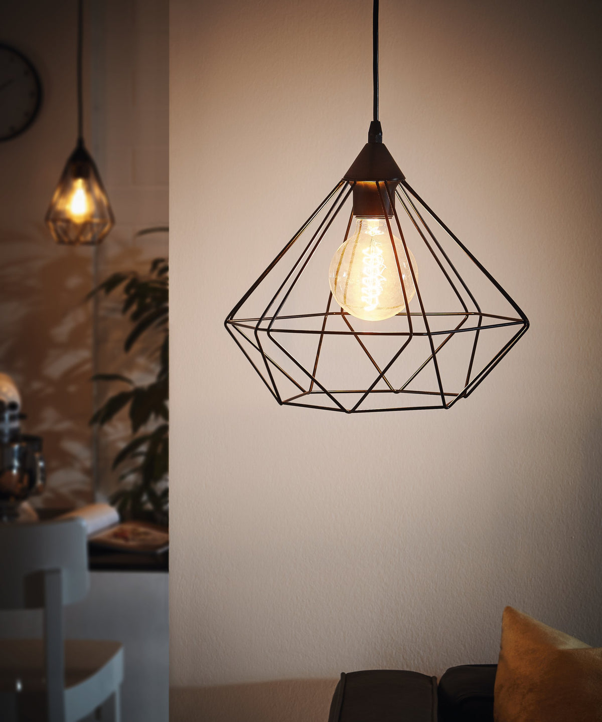 Mise en ambiance d'une suspension allumée dans un intérieur chaleureux près d'une plante