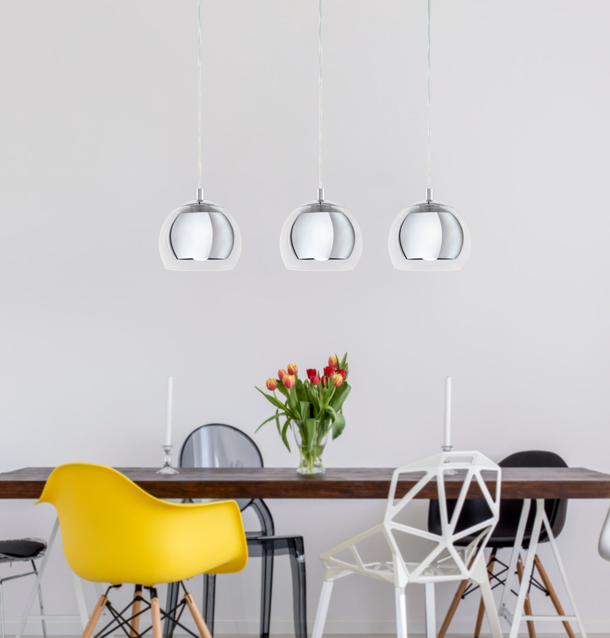 Mise en ambiance : trois suspensions au-dessus d'une table à manger en bois