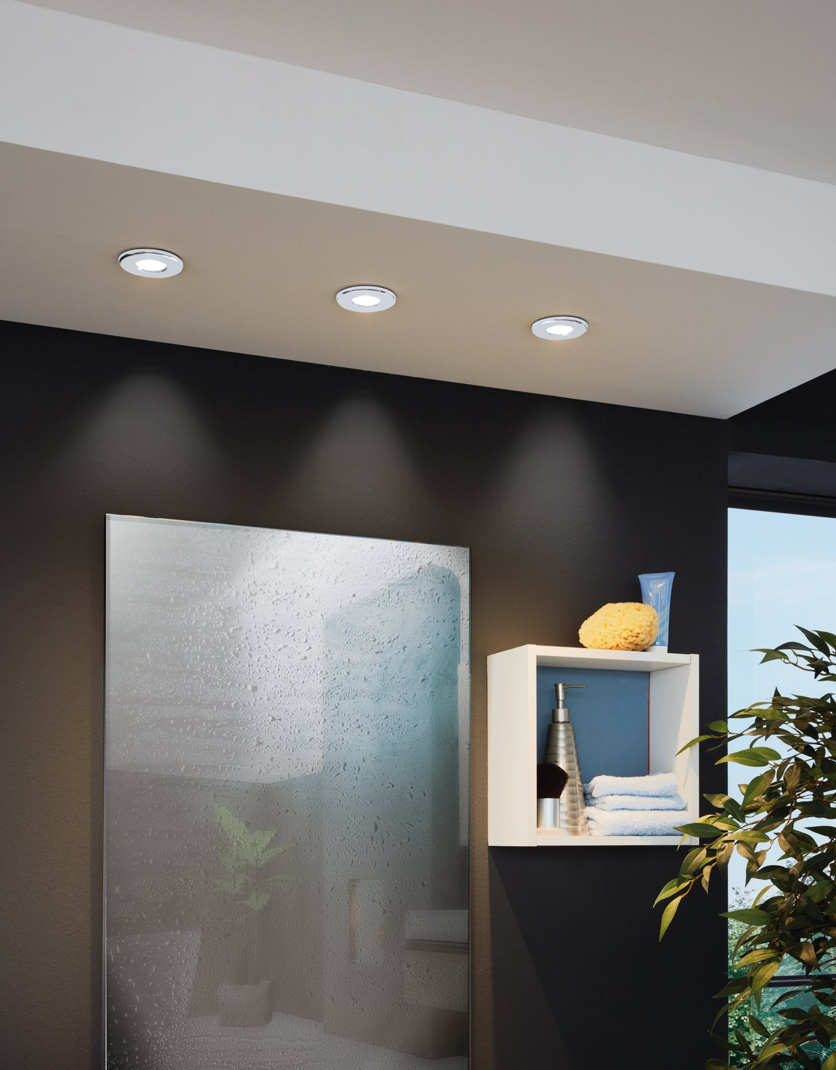 Mise en ambiance de trois spots encastrés au plafond sur mur noir