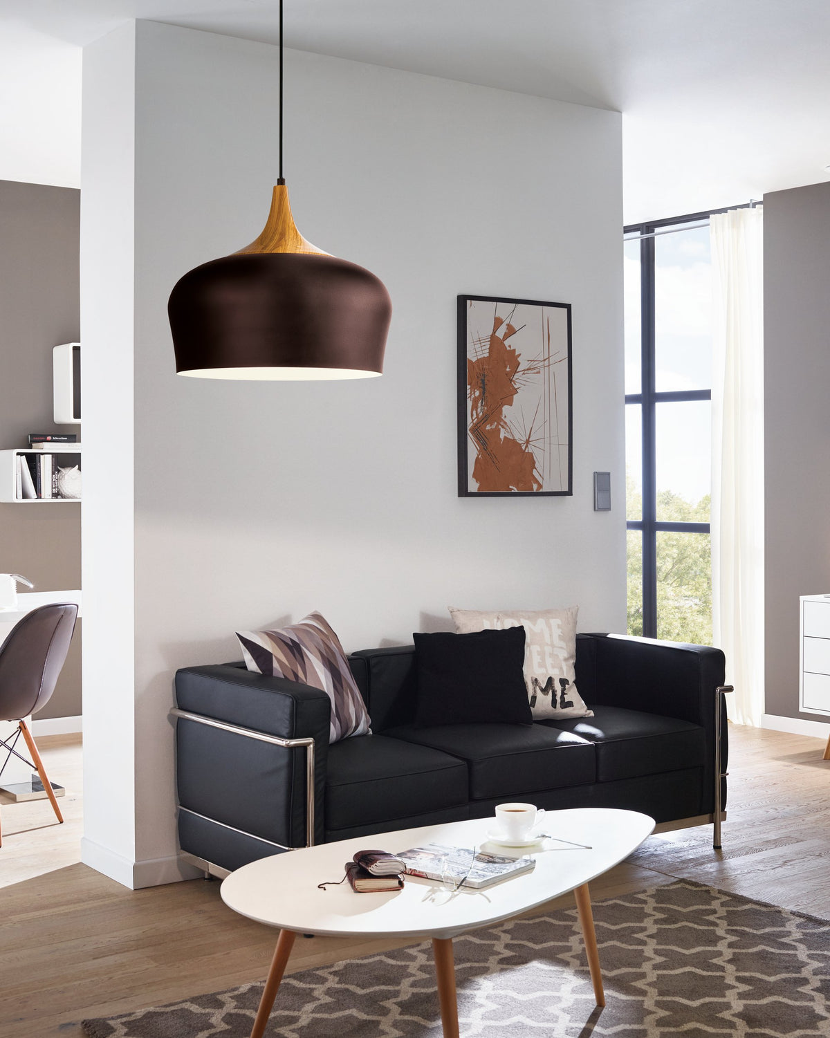 Luminaire suspendu installé dans un salon au-dessus d'un canapé noir
