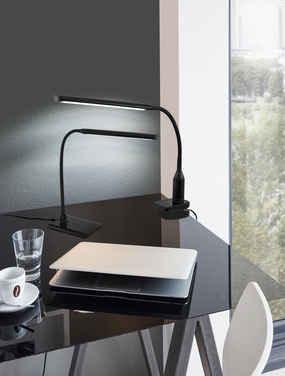 Mise en ambiance sur un bureau noir avec ordinateur portable, verre et tasse