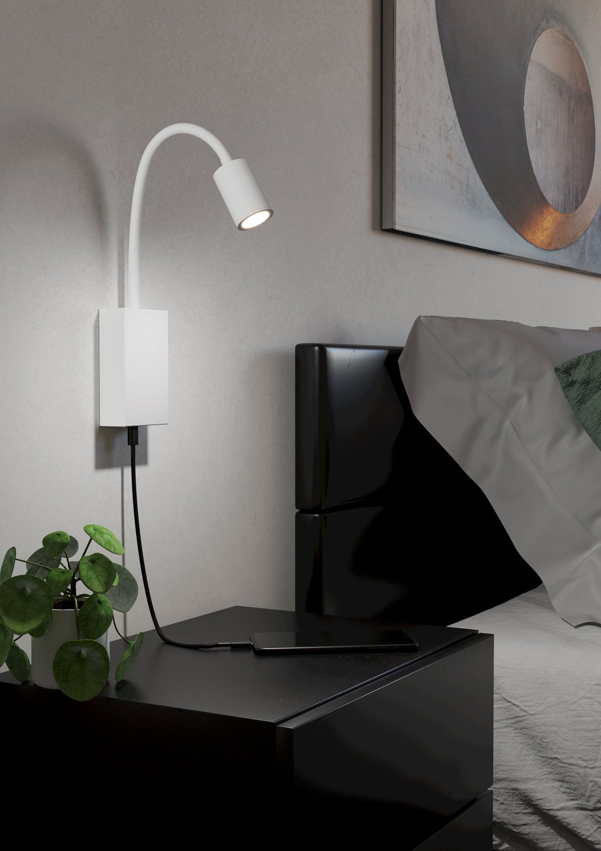 Mise en ambiance chambre : applique allumée au-dessus d'une table de nuit noire