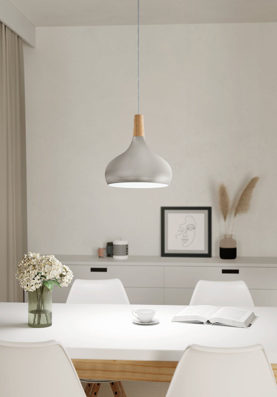 Suspension dans une salle à manger épurée avec vase de fleurs et cadre au mur.
