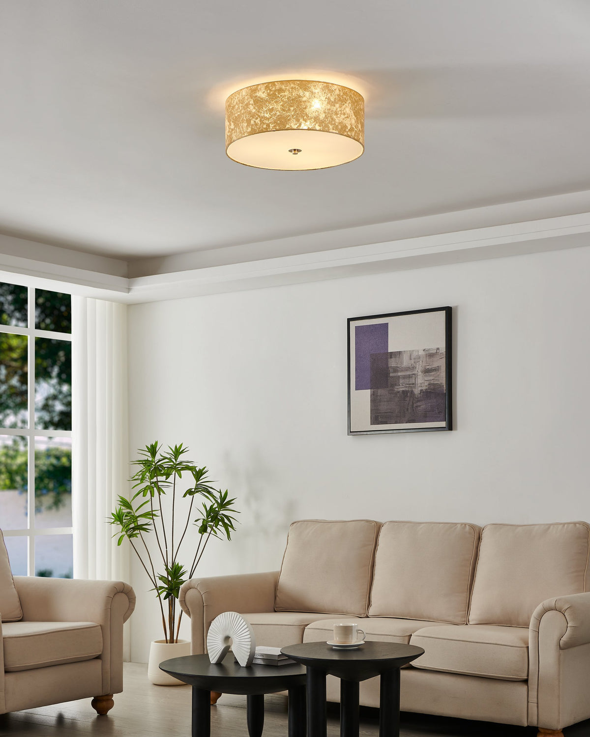 Plafonnier allumé au plafond d'un salon beige avec canapé et plante