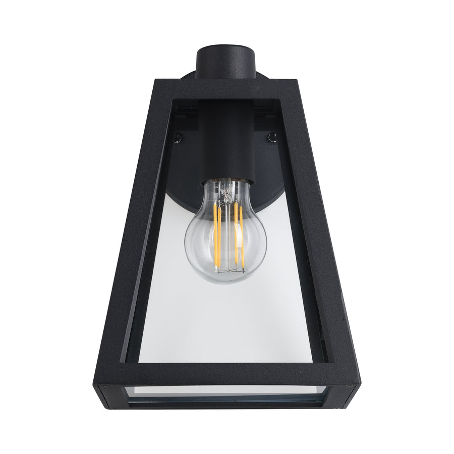 Vue de face du luminaire montrant sa silhouette trapézoïdale et l'ampoule installée à l'intérieur.