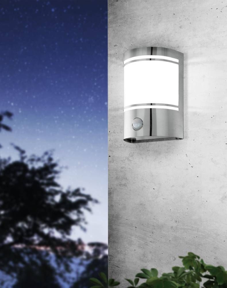 Mise en ambiance nocturne sur un mur béton, lumière allumée sous un ciel étoilé.