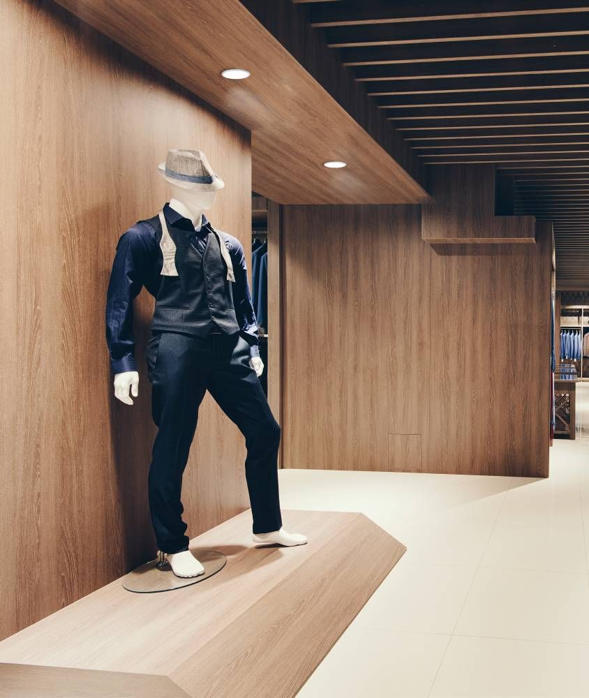 Spot encastré blanc installé au plafond bois d'un magasin de vêtements