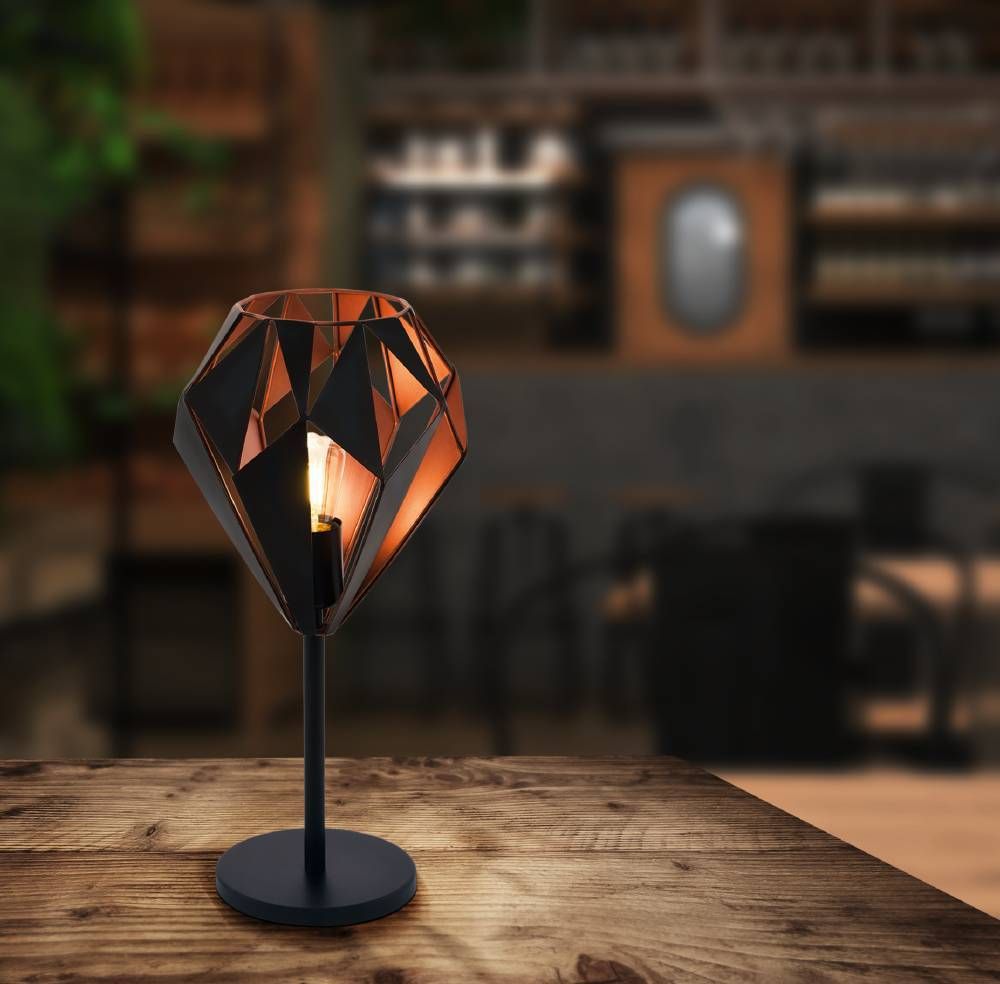 Mise en ambiance sur table en bois, lampe allumée dans un intérieur chaleureux