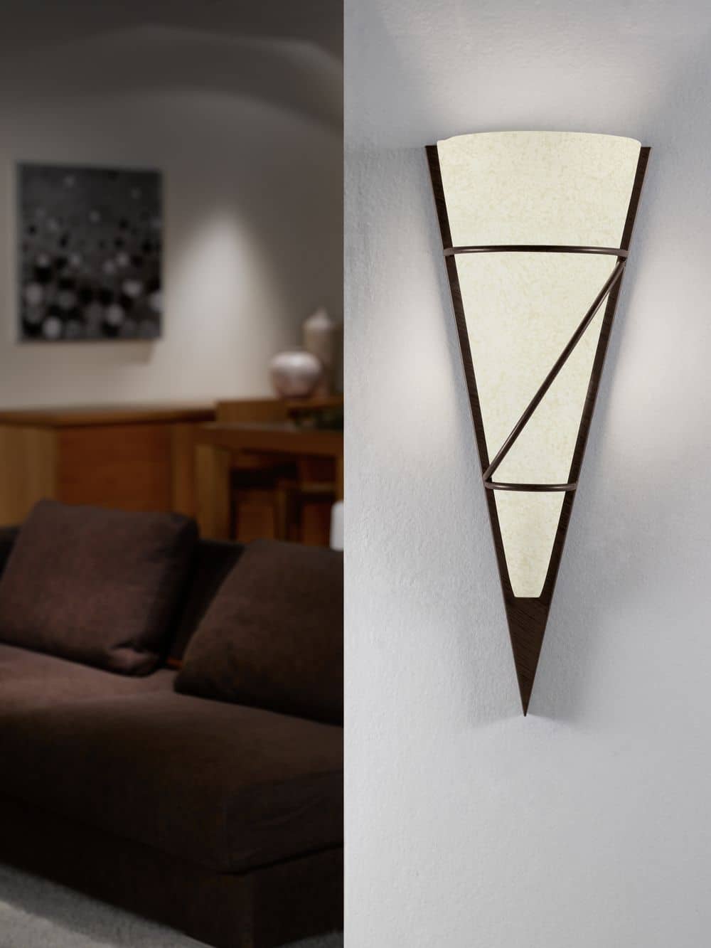 Mise en ambiance dans un salon, applique allumée sur un mur blanc près d'un canapé