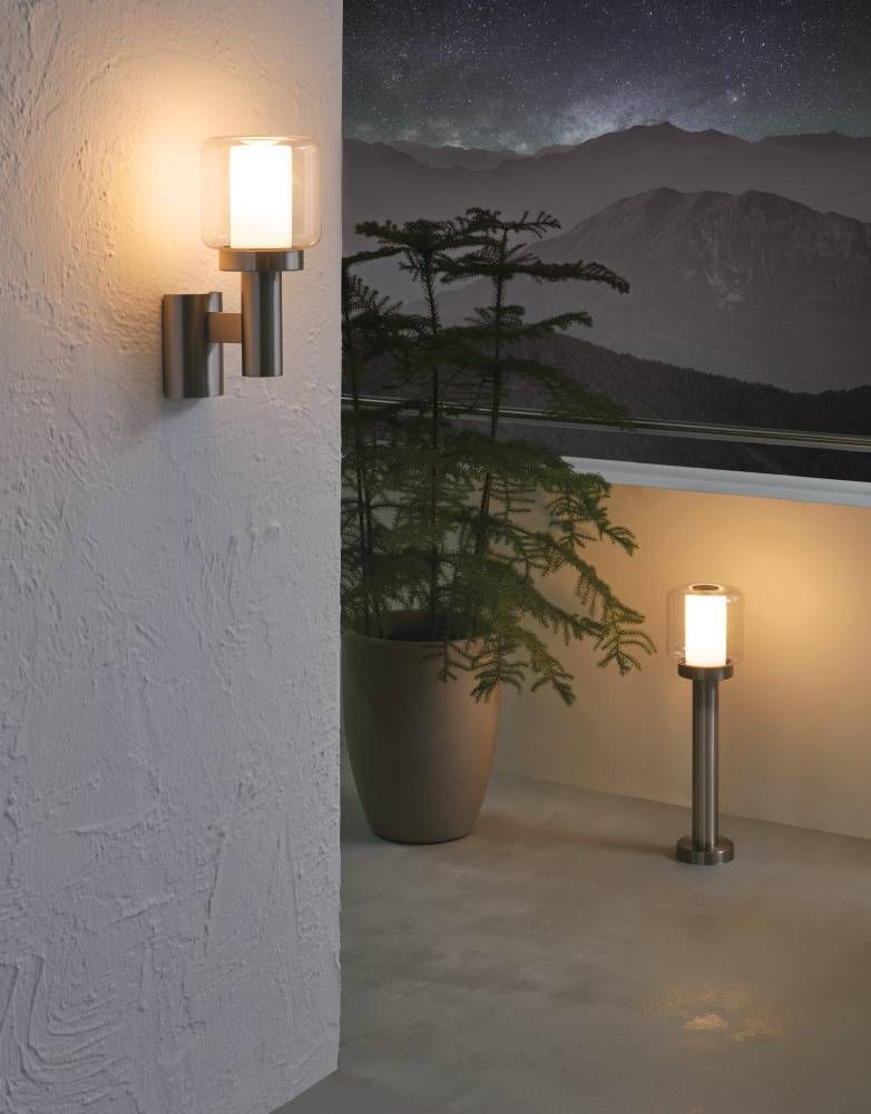 Mise en ambiance nocturne sur terrasse, applique allumée près d'un balcon montagneux