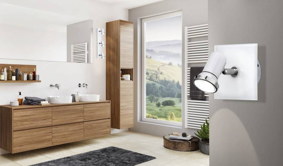 Vue d'ensemble de la salle de bain, projecteur mural blanc et chromé près de la fenêtre