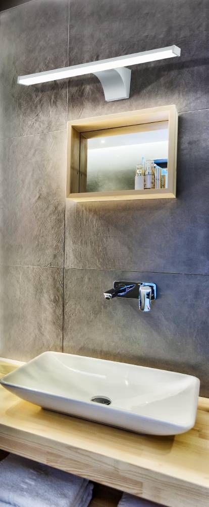 Applique murale allumée au-dessus d'un miroir dans une salle de bain moderne