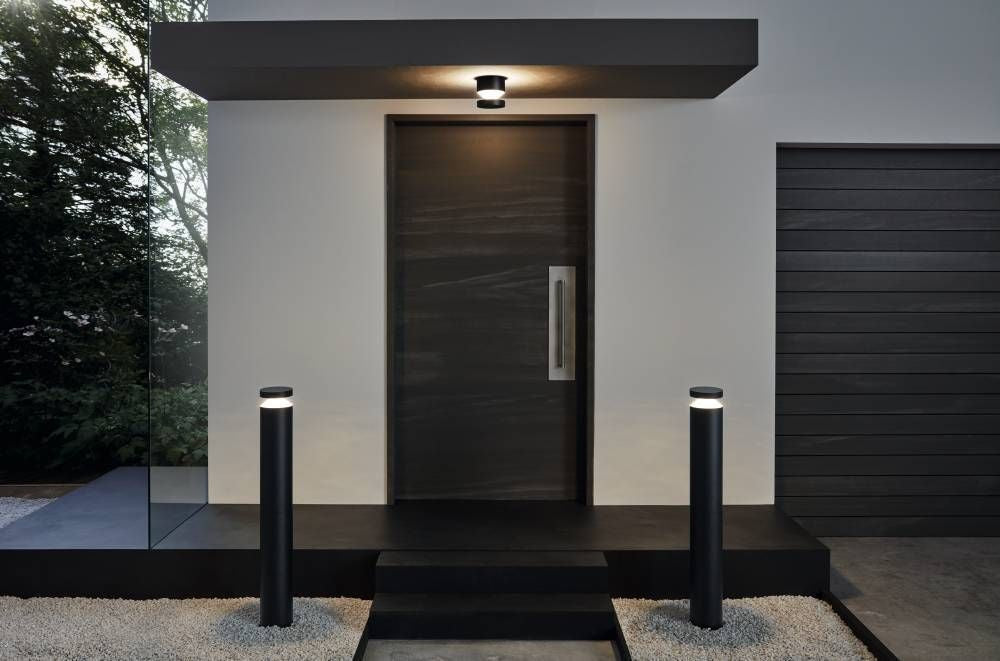 Mise en situation extérieure de l'applique noire au-dessus d'une porte avec bornes