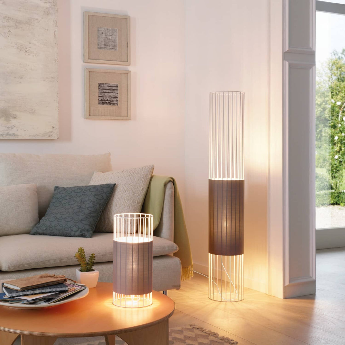Mise en ambiance salon avec lampe à poser et grand lampadaire cylindrique allumé