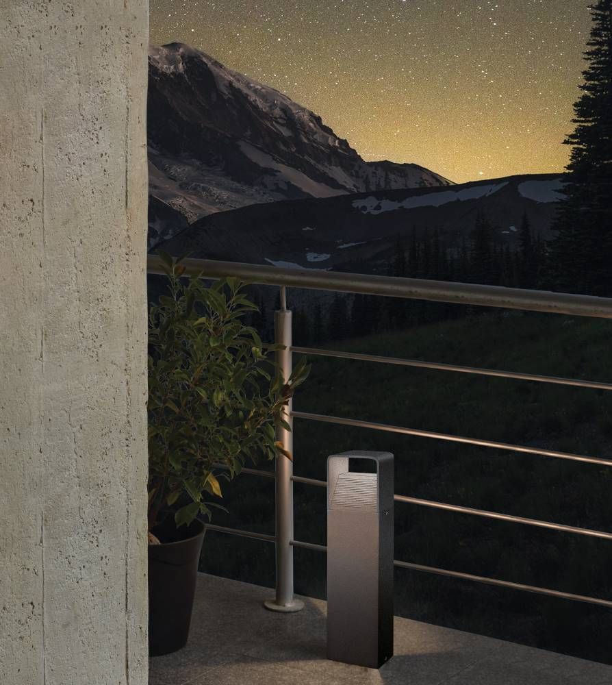 Mise en ambiance nocturne sur une terrasse en montagne, lampadaire allumé près d'une plante
