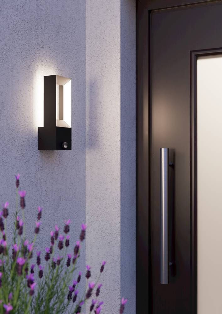 Applique murale noire et blanche installée près d'une porte, ambiance crépusculaire avec lavandes.