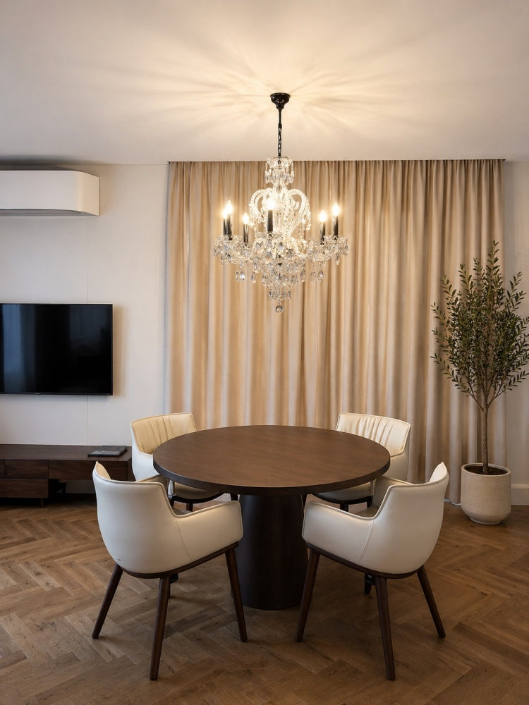 Lustre suspendu au-dessus d'une table ronde, intérieur contemporain avec rideaux beiges.