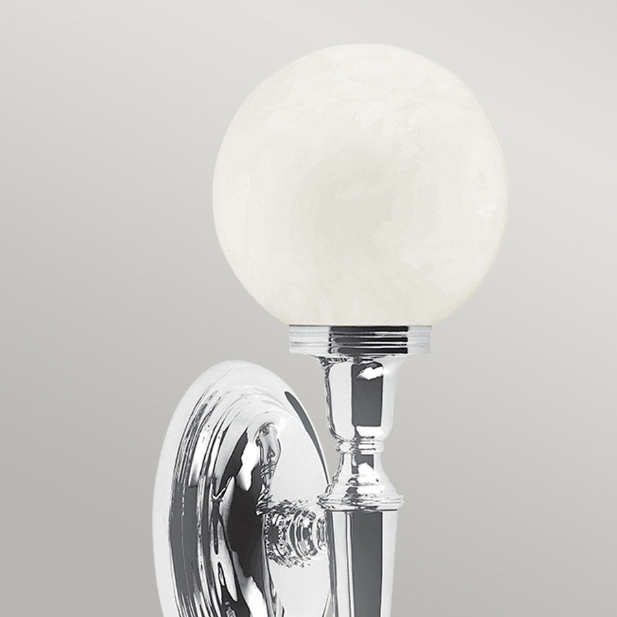 Gros plan du globe en verre dépoli et de la bague chromée cannelée.