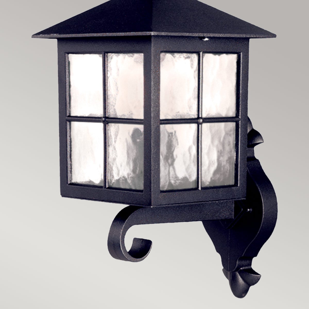 Vue rapprochée du luminaire noir montrant le verre texturé et les fixations.