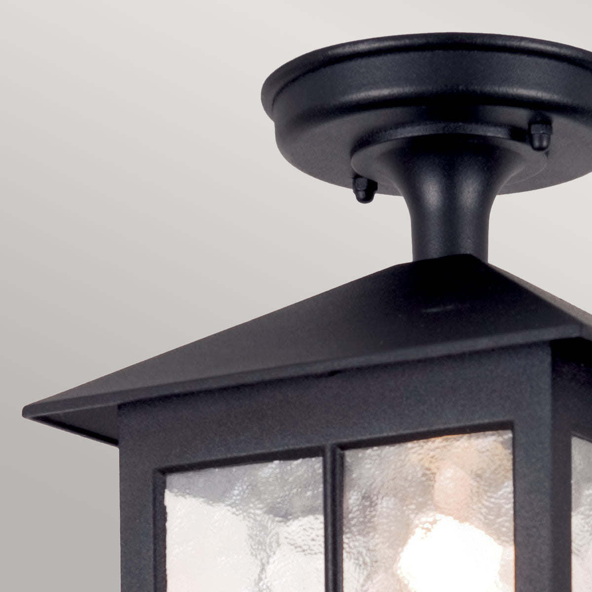 Détail du raccord circulaire au plafond et du col noir soutenant le chapeau
