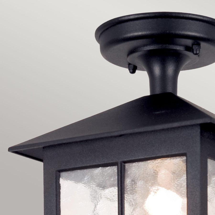 Détail du raccord circulaire au plafond et du col noir soutenant le chapeau