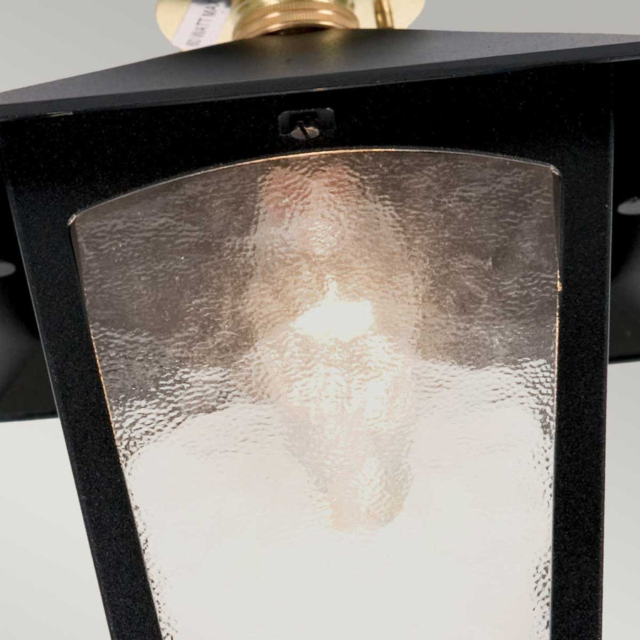 Gros plan du verre texturé et de l'ampoule allumée à l'intérieur.