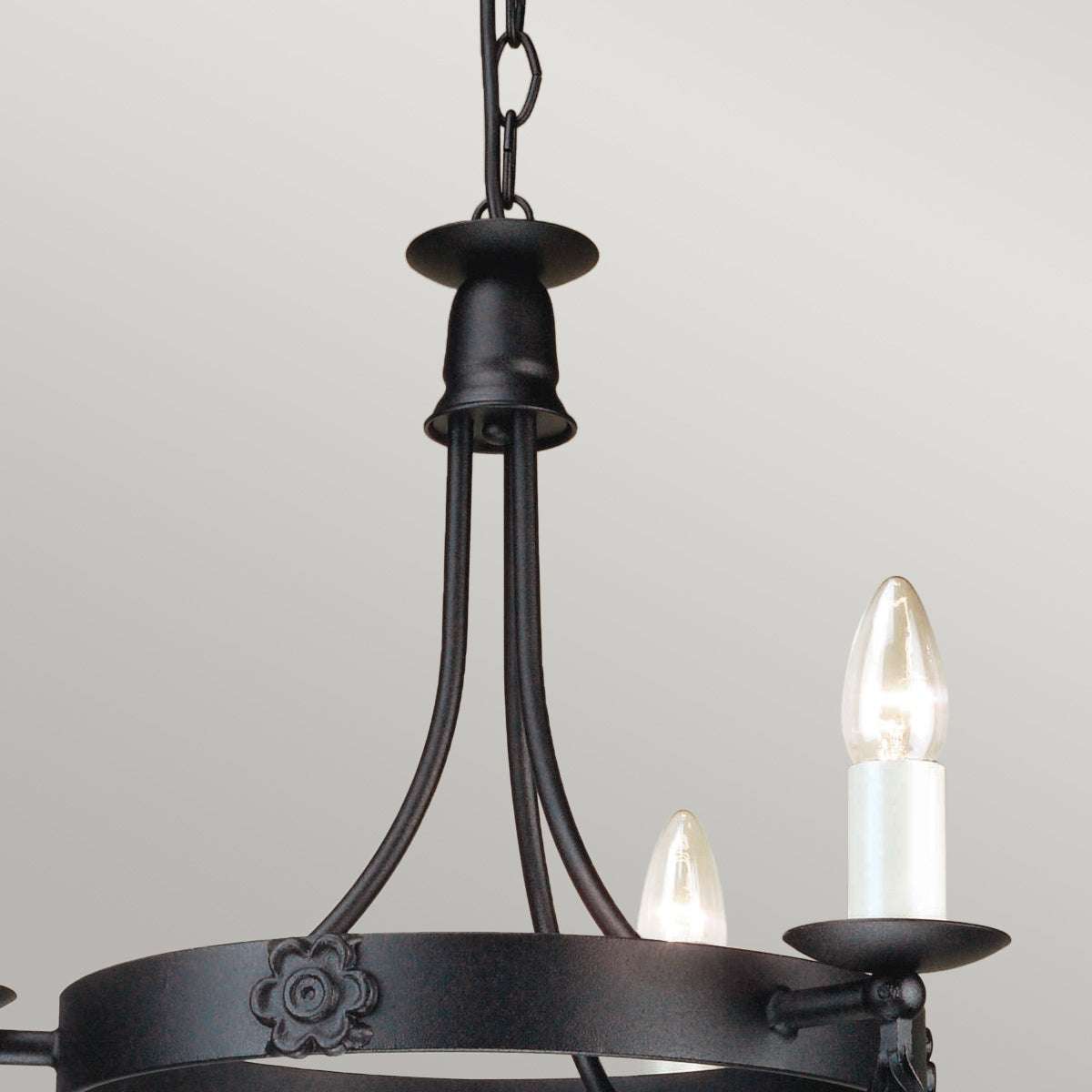 Détail de la chaîne et du support de plafond noir du luminaire.