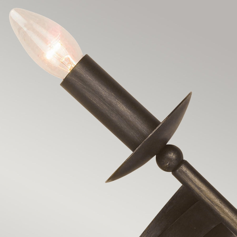 Gros plan sur une douille cylindrique et une ampoule flamme allumée, métal patiné