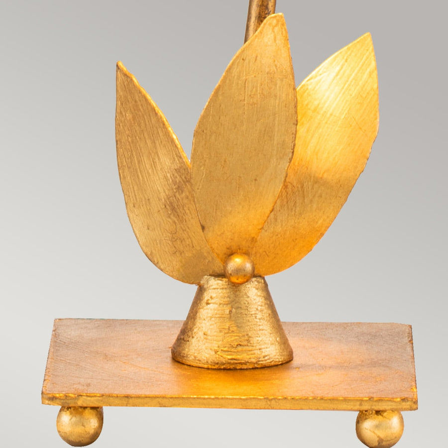 Détail de la base : trois feuilles dorées sur socle rectangulaire à petites billes.