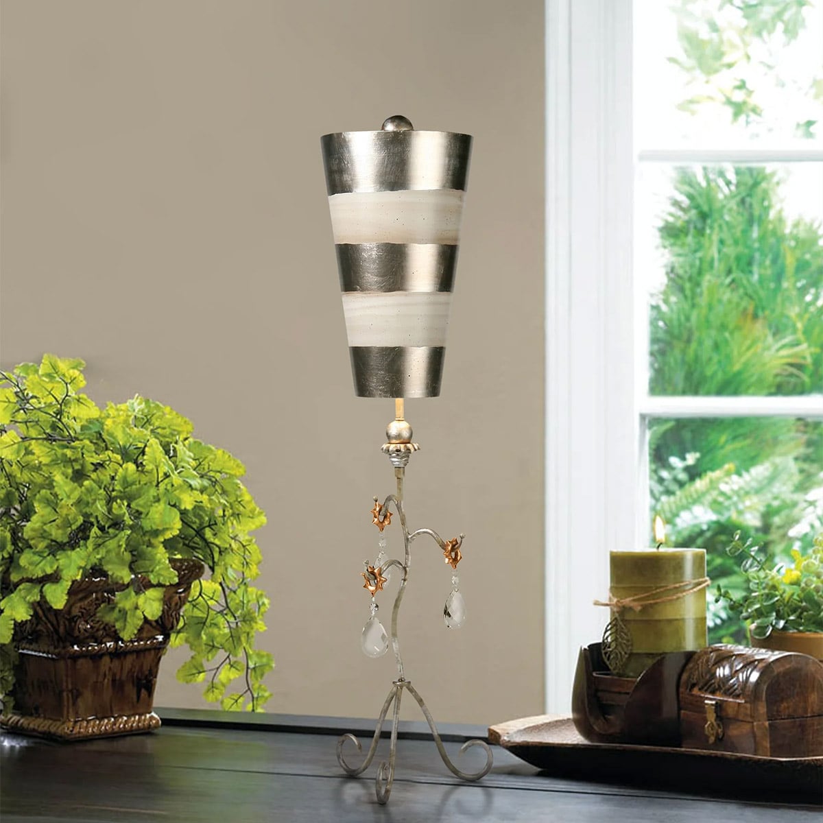 Lampe à poser sur table sombre près d'une plante verte et fenêtre.