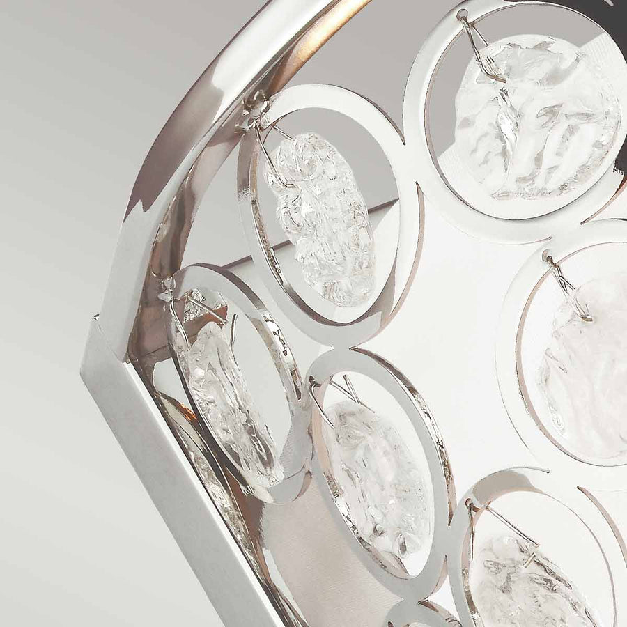 Gros plan sur les anneaux métalliques et médaillons de verre martelé de l'applique