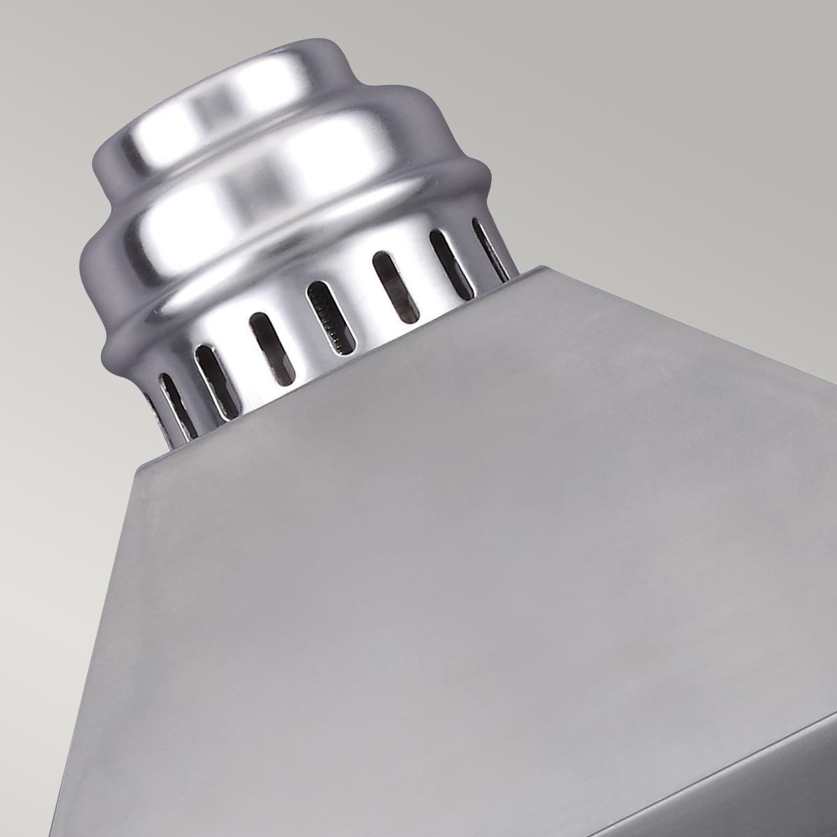 Détail du chapeau métallique argenté ajouré au sommet du luminaire
