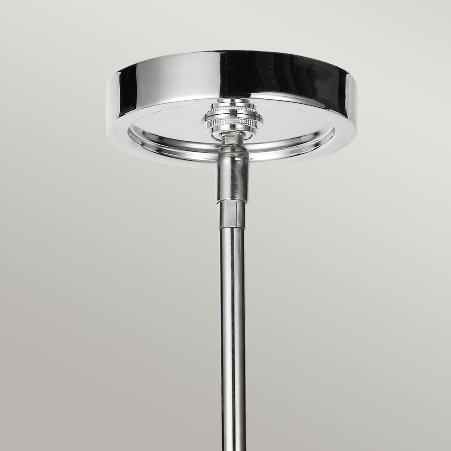 Détail de la rosace ronde en nickel poli fixée au plafond avec tige verticale